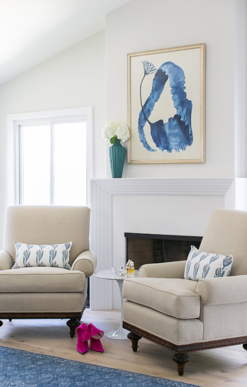 Sitting area with cream armchairs and blue abstract art
