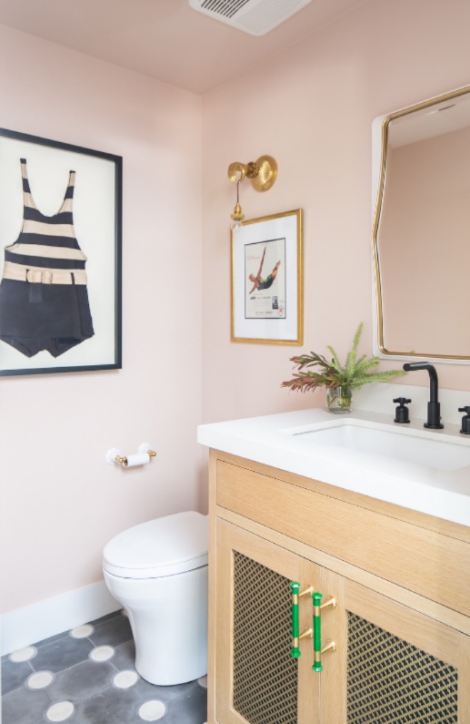 Blush powder room with woven cane vanity