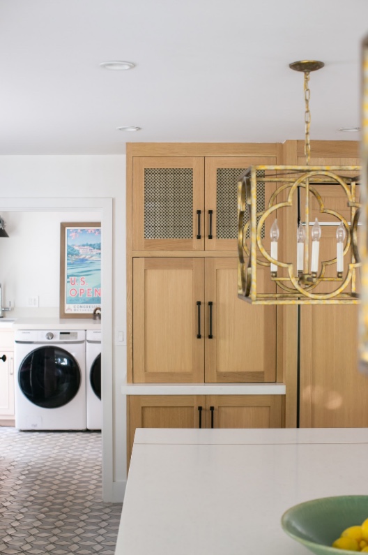 Laundry with brass lantern and oak cabinetry