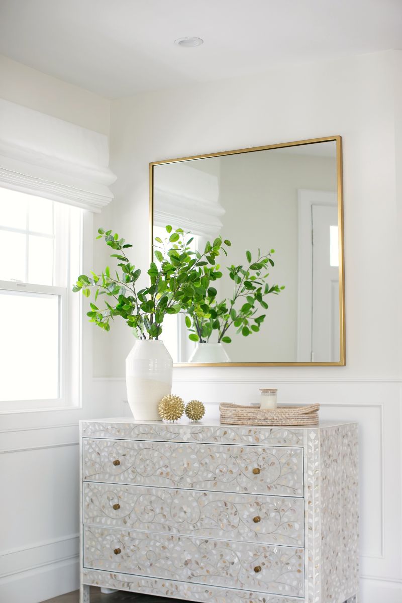 Mother-of-pearl inlaid chest beneath a gilded mirror