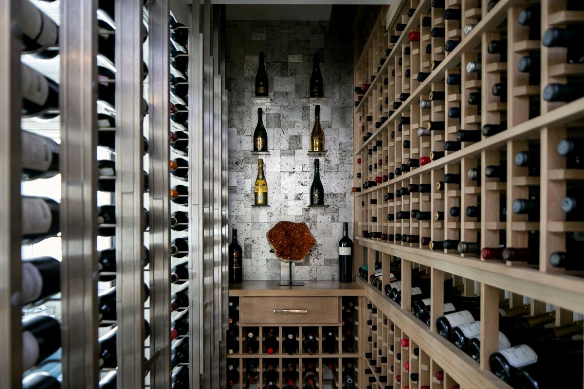 Glass-fronted wine cellar with stone wall