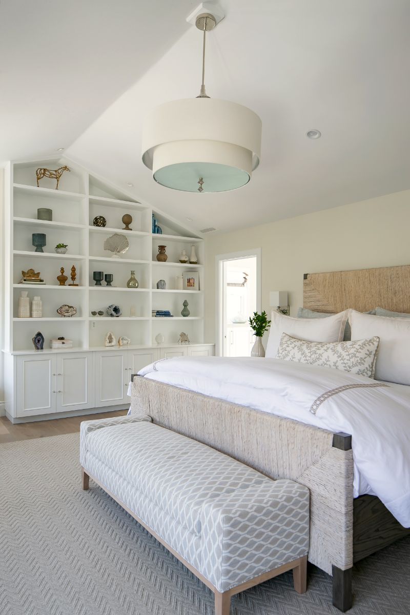 Primary bedroom with upholstered bench and drum pendant