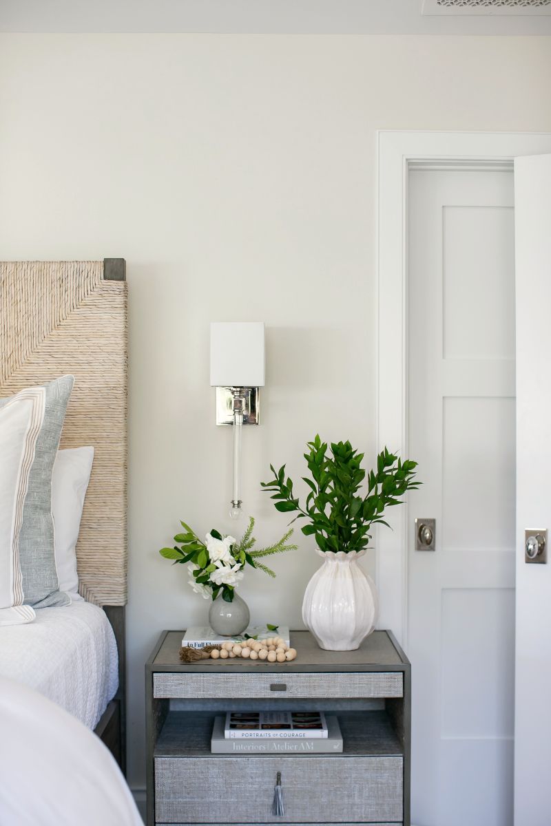Bedside with woven headboard and wall sconce