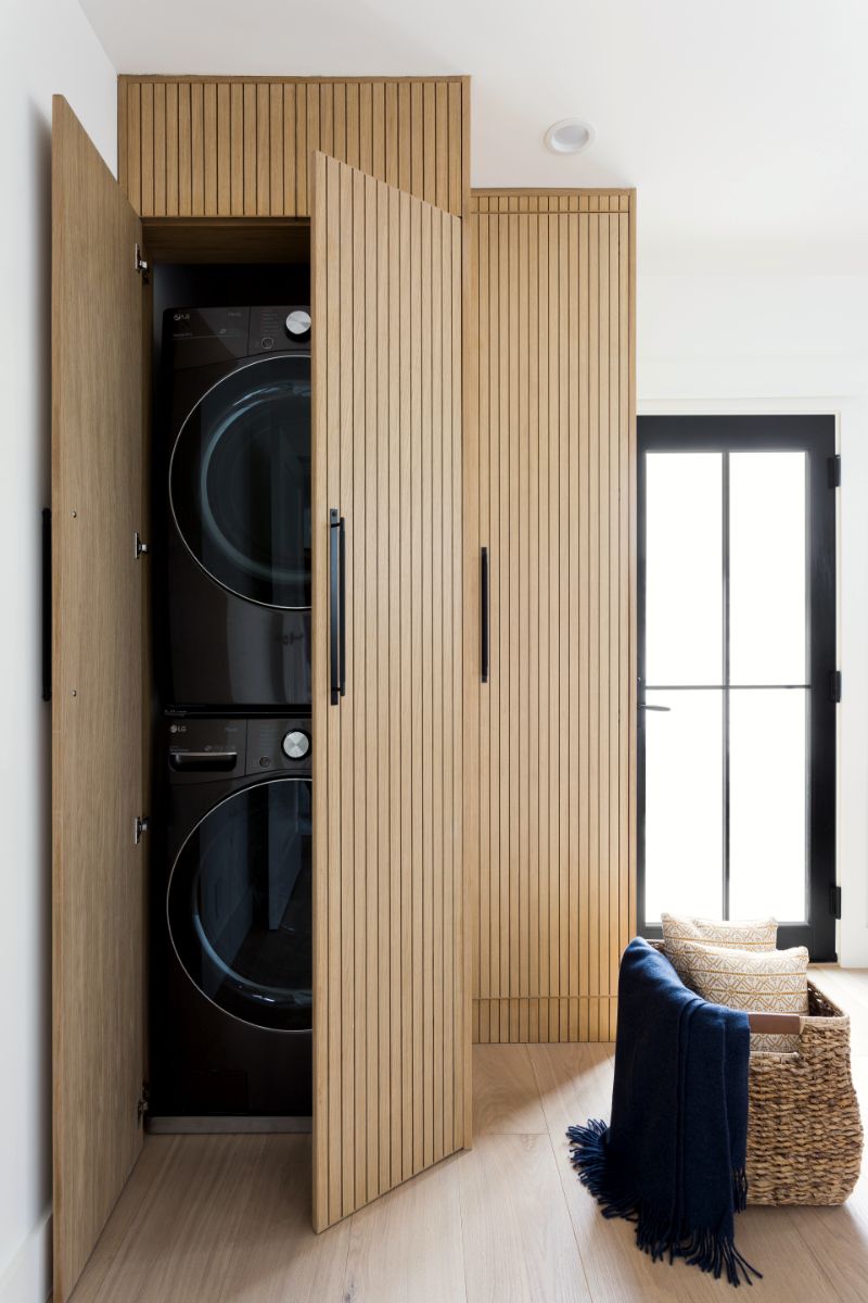 Fluted oak doors opening to a concealed laundry