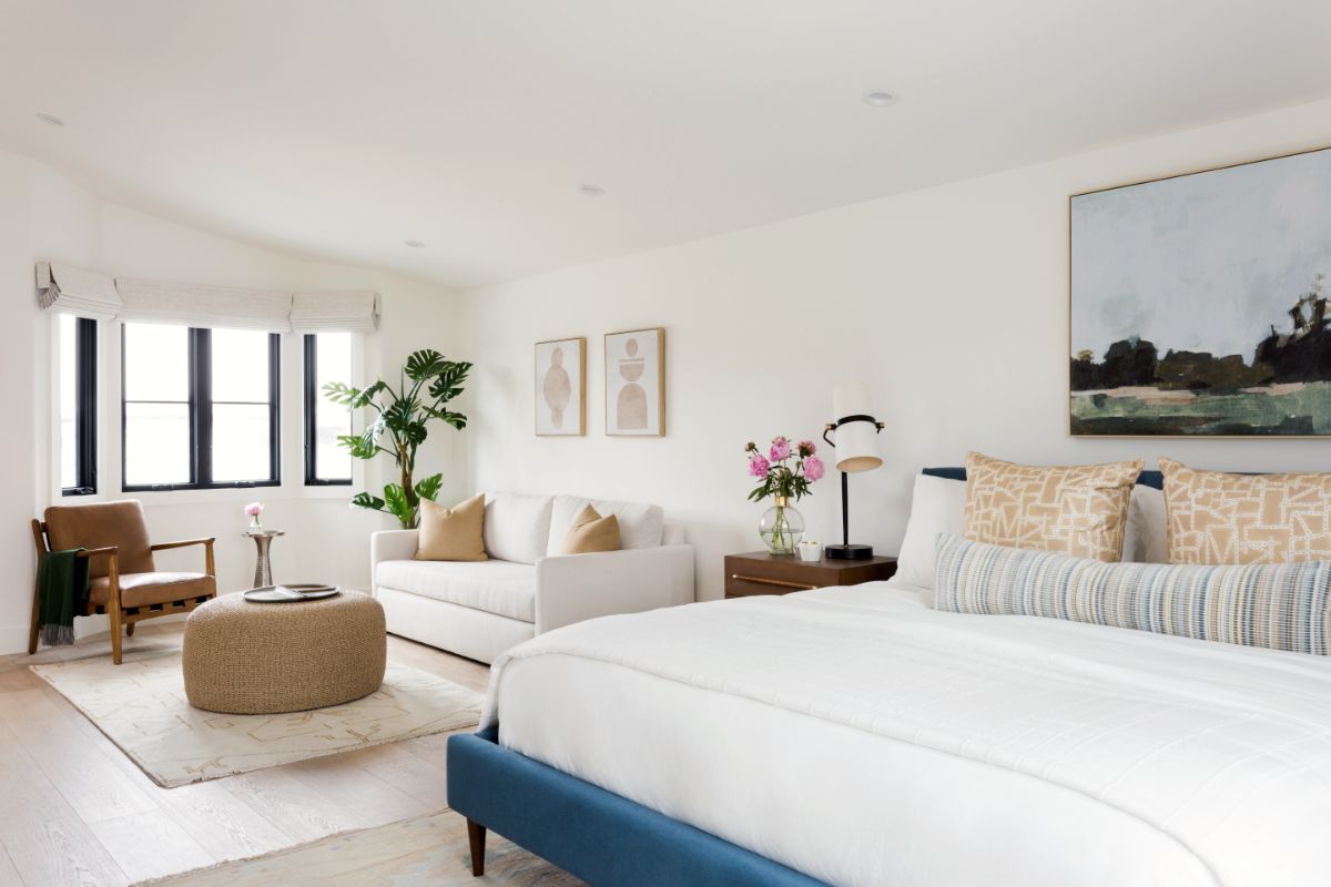 Bedroom sitting area with leather chair and woven pouf