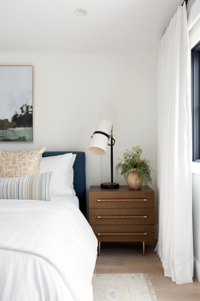 Bedside with navy headboard and wood nightstand