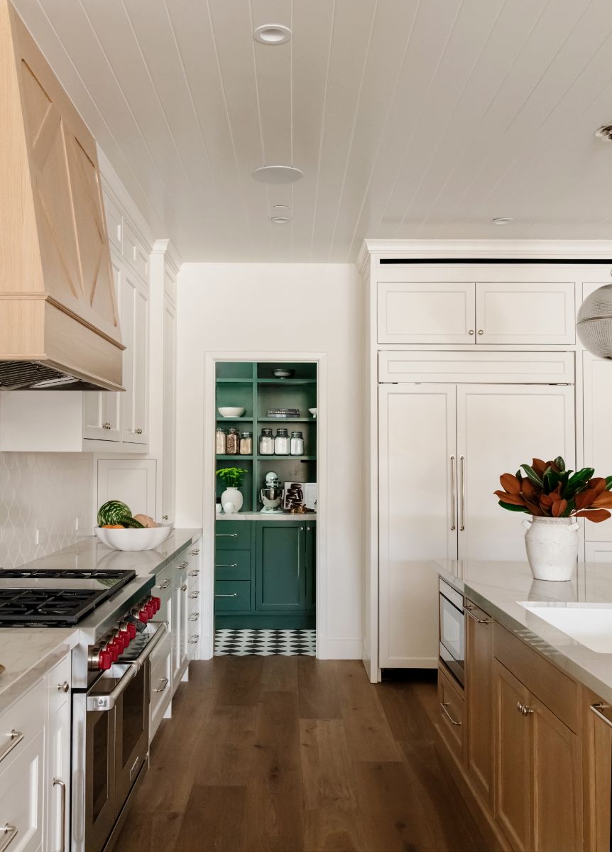 Kitchen with oak range hood looking into an emerald pantry