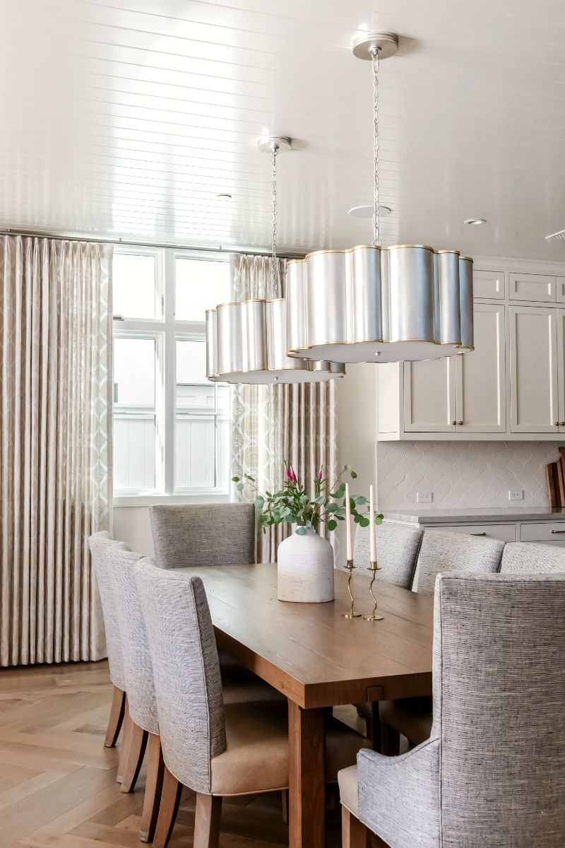 Dining room with upholstered chairs, wood table and drum pendant