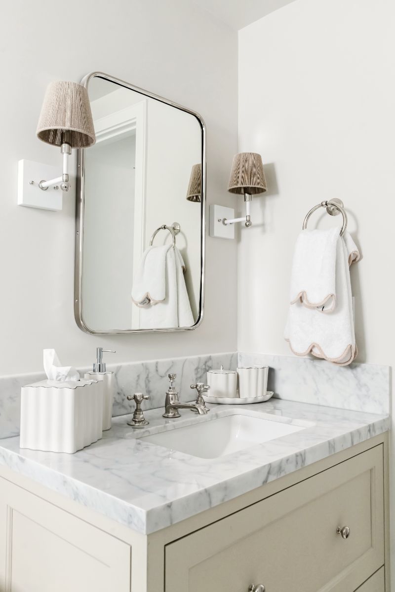 Marble vanity with brass mirror and sconces