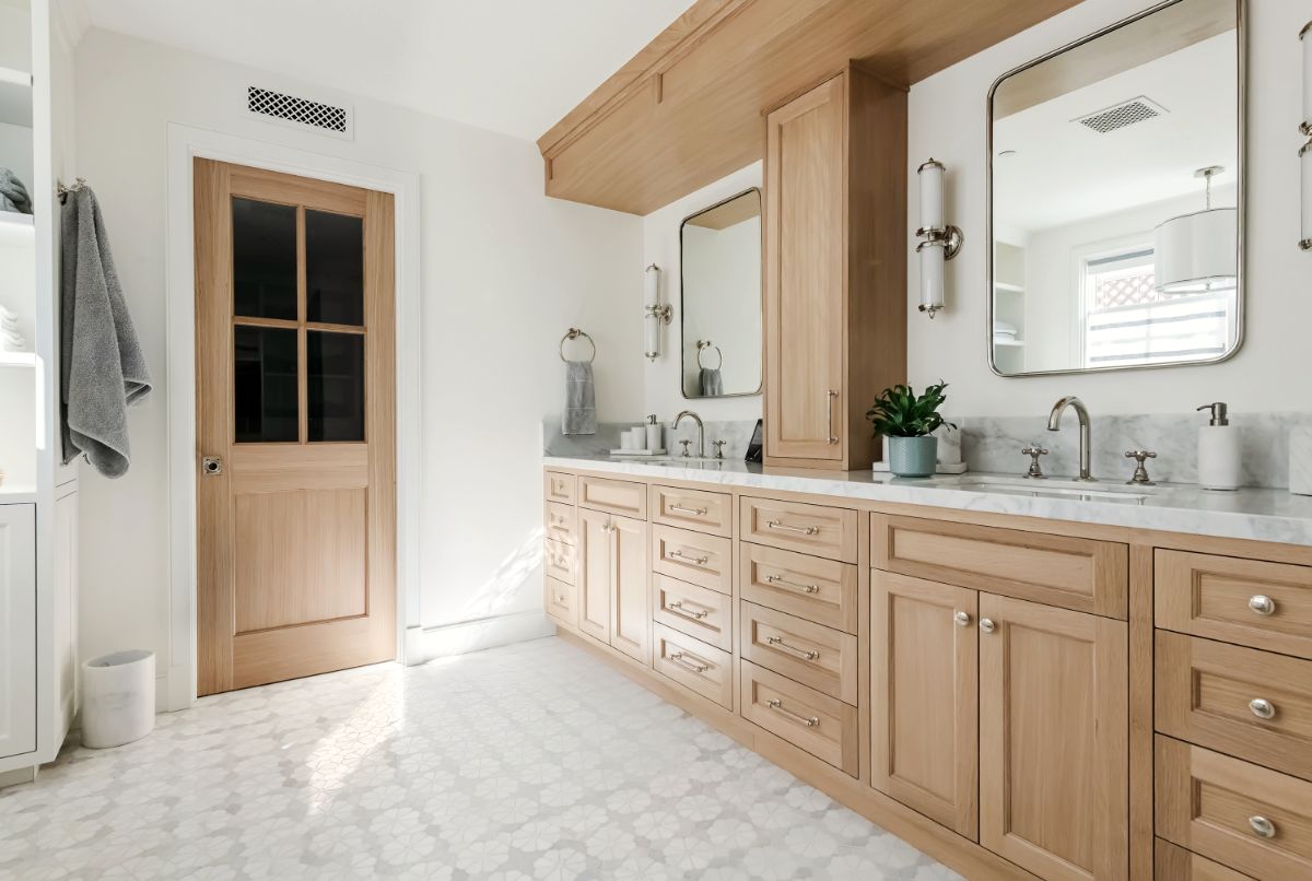 Primary bath with long white oak double vanity and marble mosaic floor