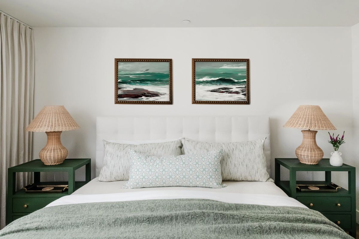 Guest bedroom with emerald nightstands, pleated lamps and seascape prints