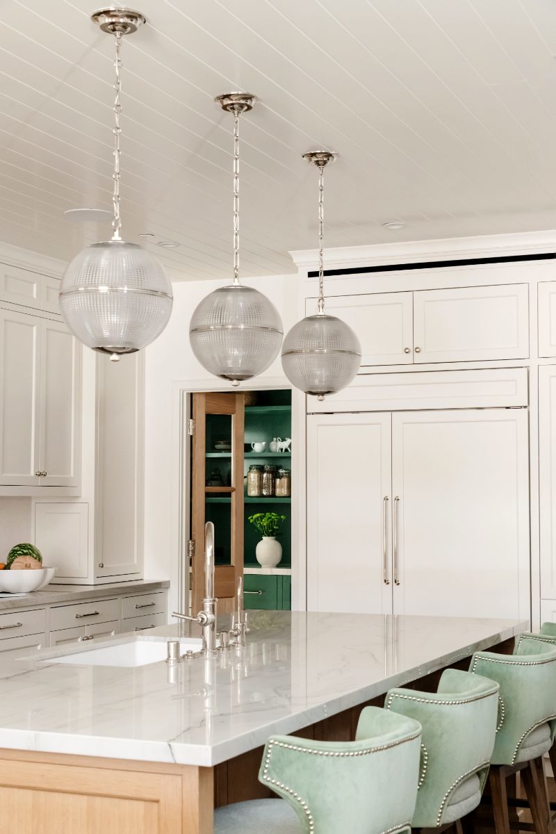Kitchen island with glass pendants and marble counters